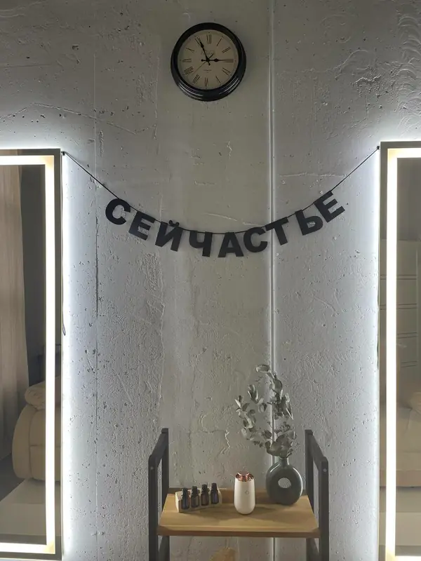 Гирлянда с надписью сейчастье на стене студии